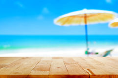 wood-table-top-blurred-beach-bac